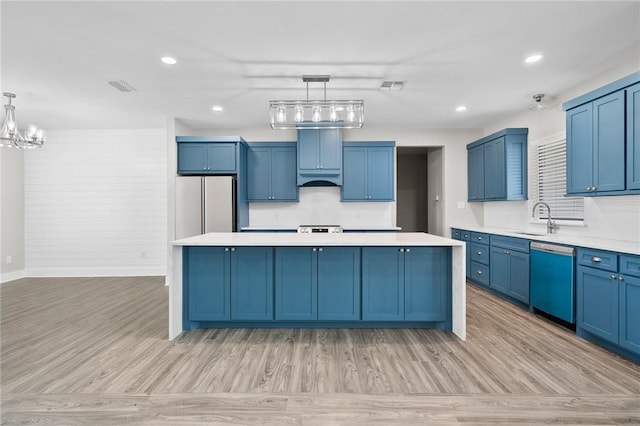 kitchen featuring dishwasher, white refrigerator, a kitchen island, and hanging light fixtures