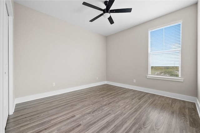 empty room with hardwood / wood-style floors and ceiling fan