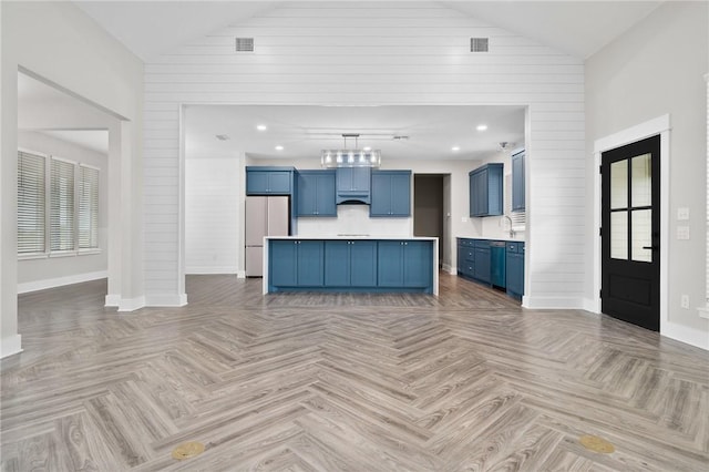 unfurnished living room featuring wood walls, light parquet flooring, and high vaulted ceiling