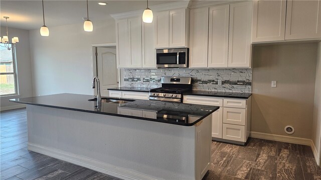 kitchen featuring a kitchen island with sink, appliances with stainless steel finishes, sink, and pendant lighting