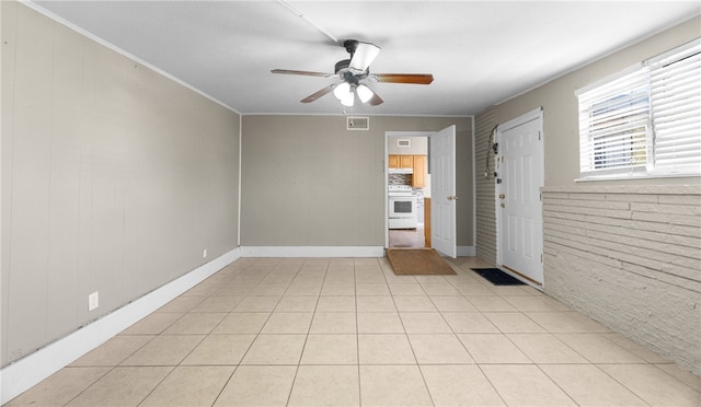 tiled spare room featuring ceiling fan and crown molding