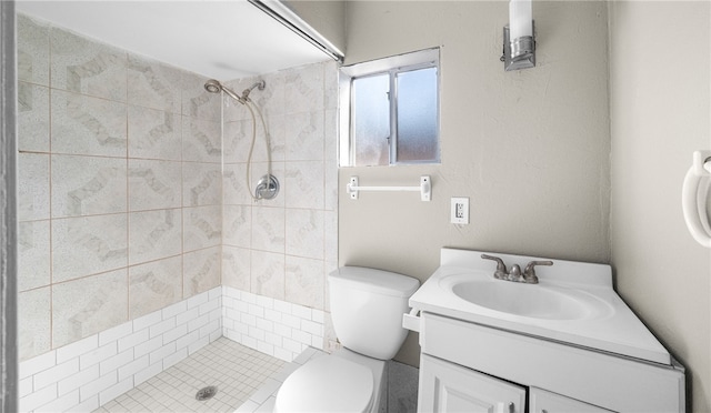 bathroom with vanity, toilet, and tiled shower