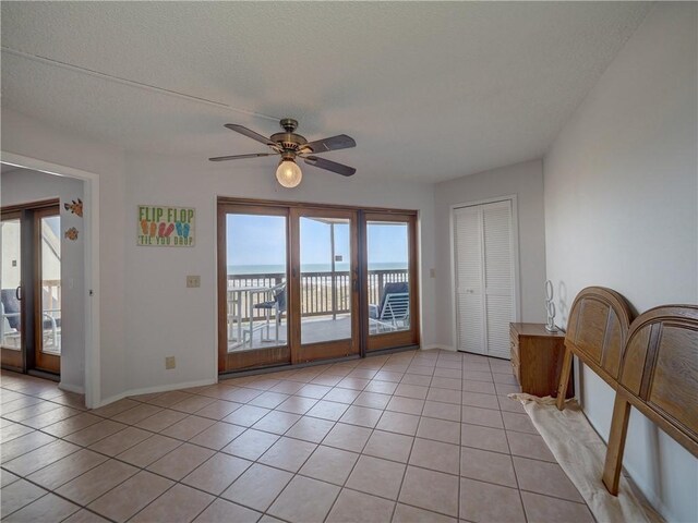5973 State Highway 361 Unit 433, Port Aransas, TX 78373 - spare room featuring healthy amount of natural light, a ceiling fan, light tile patterned floors, and baseboards