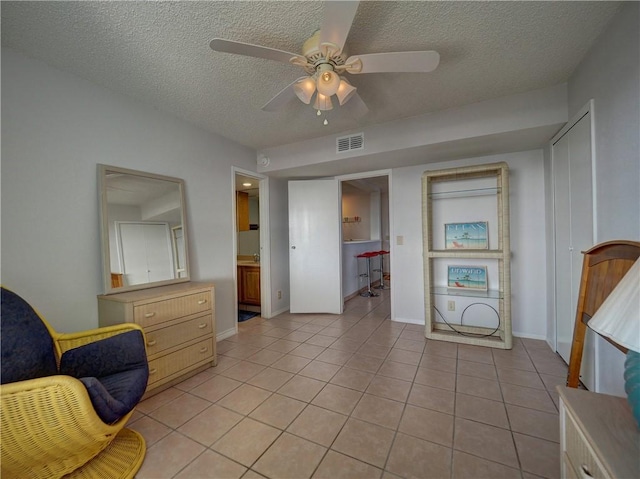 5973 State Highway 361 Unit 433, Port Aransas, TX 78373 - living area featuring a textured ceiling, light tile patterned floors, a ceiling fan, and baseboards