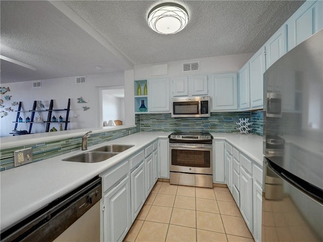 5973 State Highway 361 Unit 433, Port Aransas, TX 78373 - kitchen featuring stainless steel appliances, a sink, a textured ceiling, light countertops, and decorative backsplash