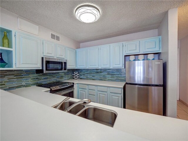 5973 State Highway 361 Unit 433, Port Aransas, TX 78373 - kitchen featuring appliances with stainless steel finishes, light countertops, decorative backsplash, a sink, and a textured ceiling