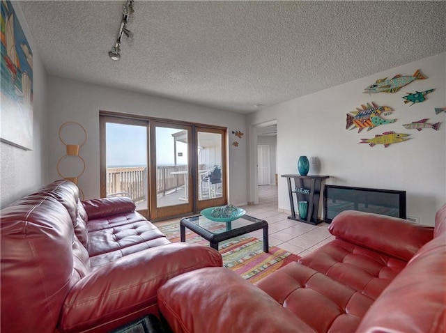 5973 State Highway 361 Unit 433, Port Aransas, TX 78373 - living area featuring rail lighting, light tile patterned flooring, a textured ceiling, and baseboards