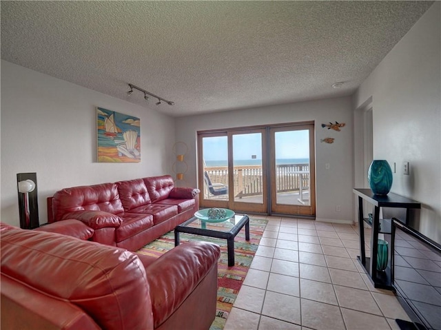 5973 State Highway 361 Unit 433, Port Aransas, TX 78373 - living room with track lighting, light tile patterned flooring, a textured ceiling, and baseboards