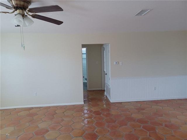 tiled spare room featuring ceiling fan