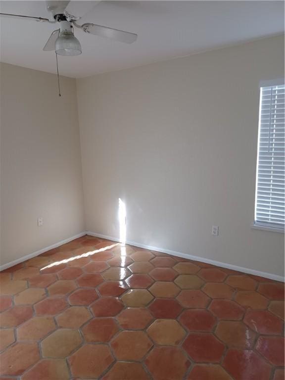 tiled spare room featuring ceiling fan