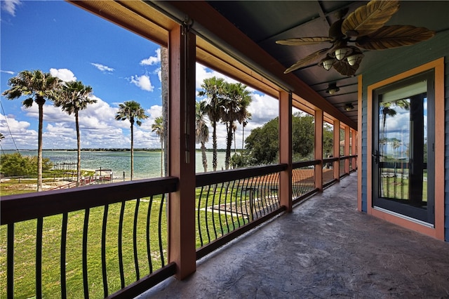 balcony featuring a water view and ceiling fan