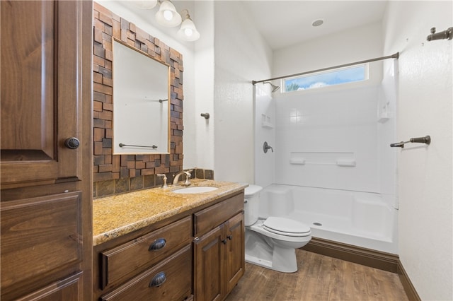 bathroom featuring walk in shower, vanity, toilet, and hardwood / wood-style floors