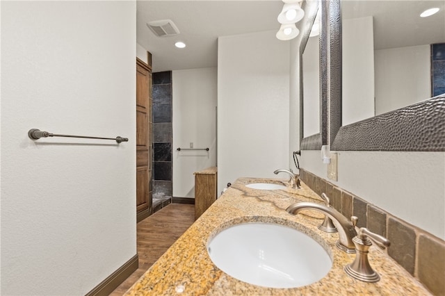 bathroom with hardwood / wood-style floors, vanity, and a shower