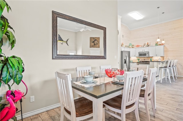 dining space featuring ornamental molding, light hardwood / wood-style floors, and ceiling fan