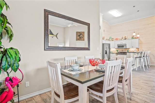 623 Sandkey Dr, Port Aransas, TX 78373 - dining room with light wood-style flooring, crown molding, baseboards, and a ceiling fan