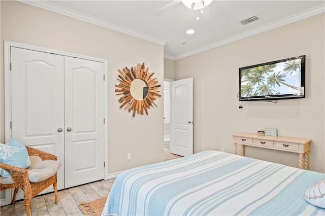 bedroom with ceiling fan, a closet, light hardwood / wood-style flooring, and crown molding