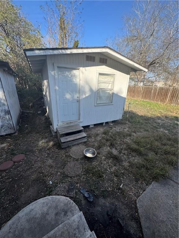 view of outdoor structure with an outbuilding and fence