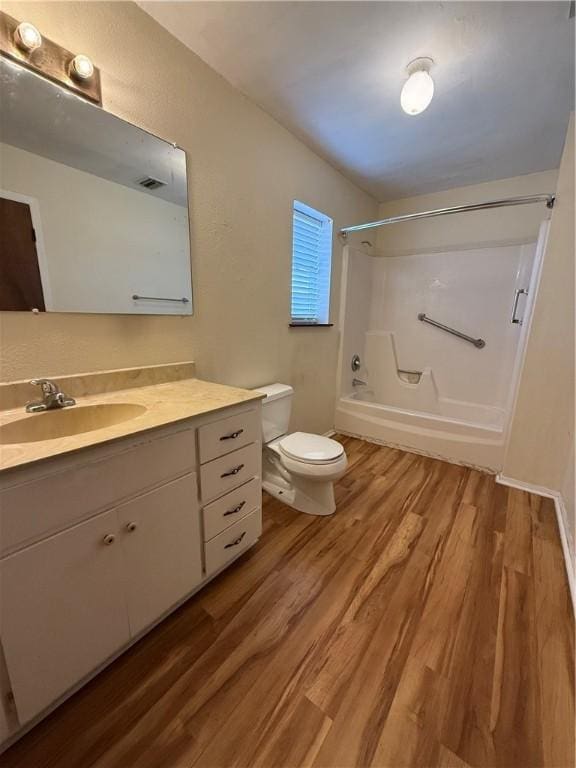 bathroom featuring vanity, shower / bath combination, wood finished floors, and toilet