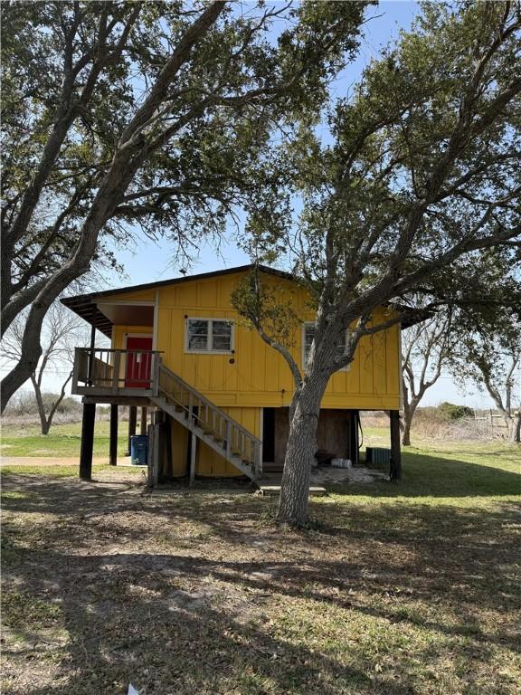 view of front of house featuring stairway and a front yard