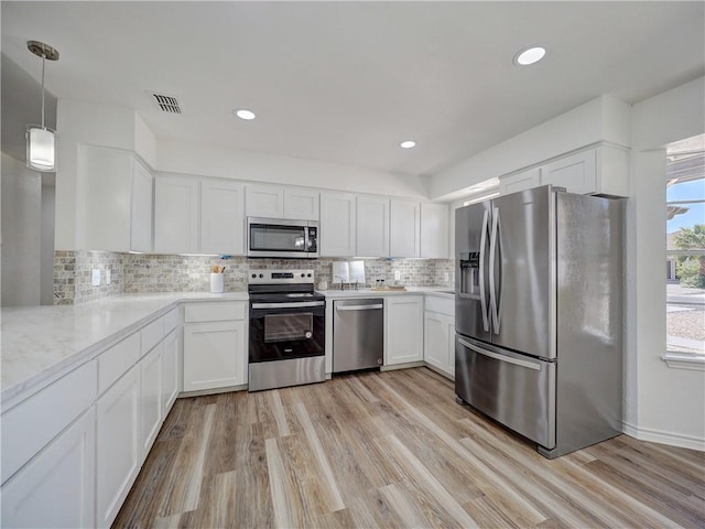 13818 Halyard Dr, Corpus Christi, TX 78418 - kitchen featuring light wood-style flooring, appliances with stainless steel finishes, and white cabinets