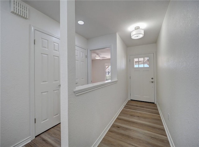 entryway with wood finished floors, visible vents, and baseboards