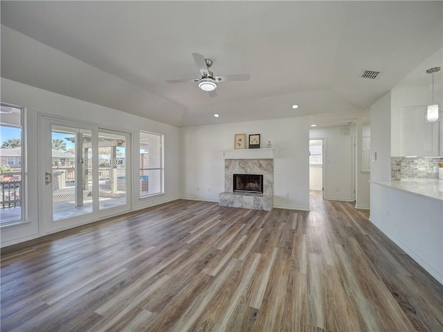 13818 Halyard Dr, Corpus Christi, TX 78418 - unfurnished living room featuring a healthy amount of sunlight, visible vents, wood finished floors, and a high end fireplace