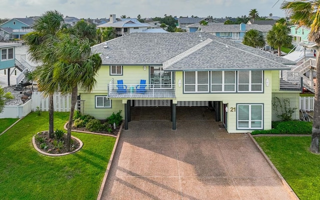 view of front of property featuring a front yard, a sunroom, and a carport