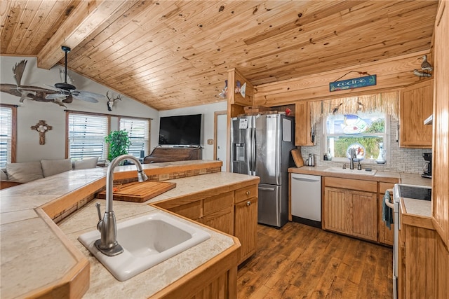 kitchen featuring stainless steel appliances, dark wood-type flooring, hanging light fixtures, sink, and lofted ceiling with beams