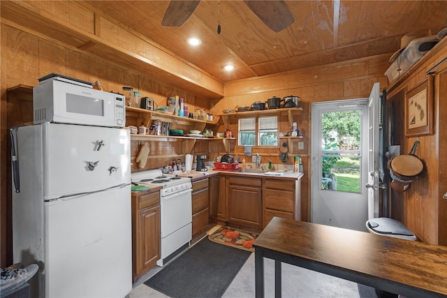 kitchen featuring wooden walls, sink, wooden ceiling, ceiling fan, and white appliances