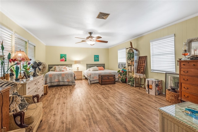 bedroom featuring ceiling fan, cooling unit, light wood-type flooring, and ornamental molding