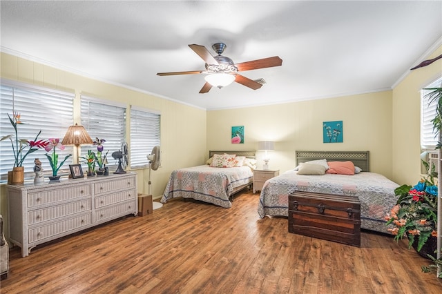 bedroom featuring hardwood / wood-style floors, ceiling fan, and ornamental molding