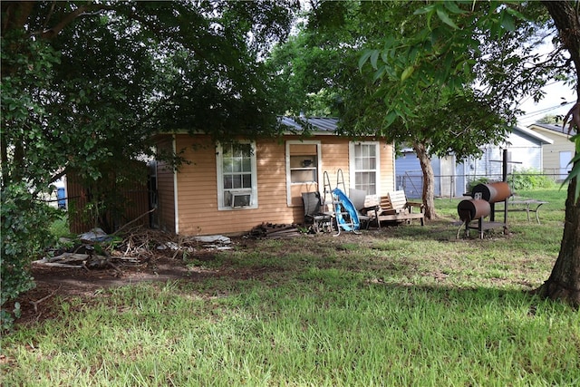 exterior space featuring cooling unit and a front lawn