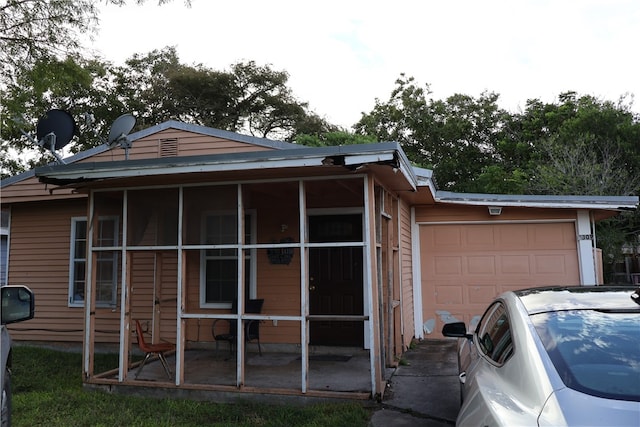 view of side of home with a garage and a sunroom