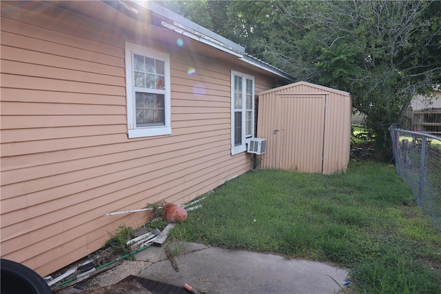 view of side of home with a lawn and a shed