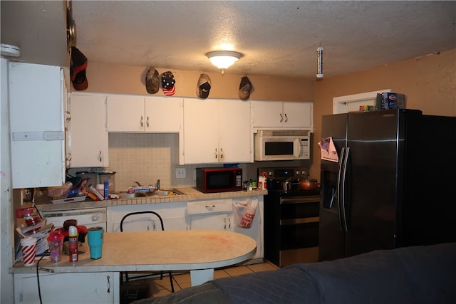 kitchen featuring black appliances, tasteful backsplash, sink, and white cabinets