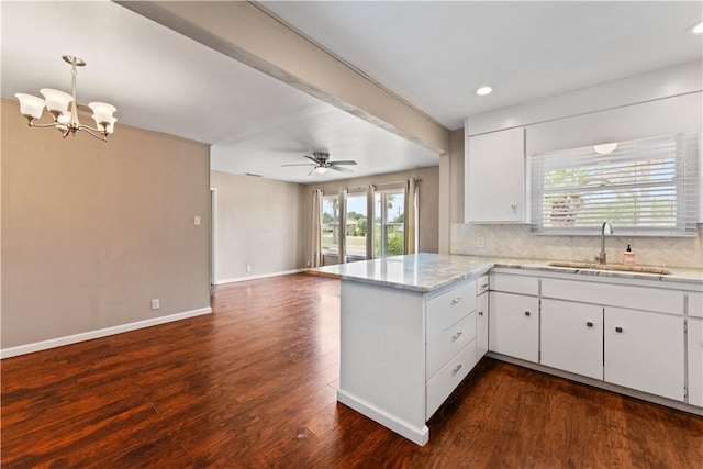 4002 Brawner Pkwy, Corpus Christi, TX 78411 - kitchen with a sink, a peninsula, decorative backsplash, white cabinetry, and open floor plan