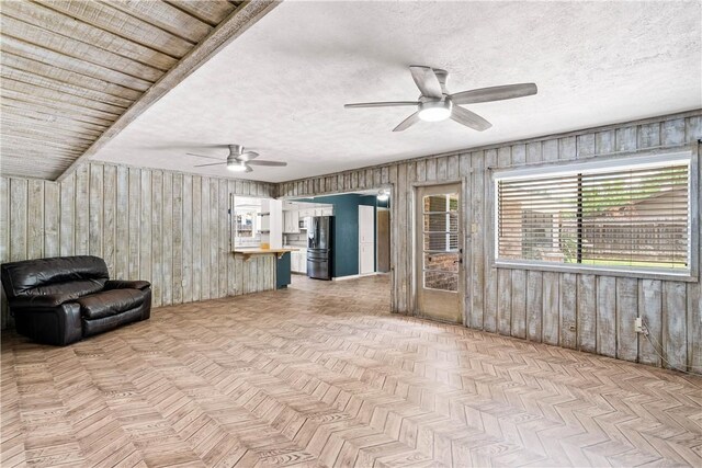 5110 Cascade Dr, Corpus Christi, TX 78413 - unfurnished living room featuring ceiling fan, wood walls, and a textured ceiling