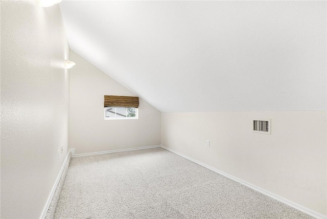 additional living space featuring carpet flooring and lofted ceiling