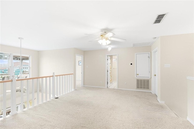 empty room featuring ceiling fan and light carpet