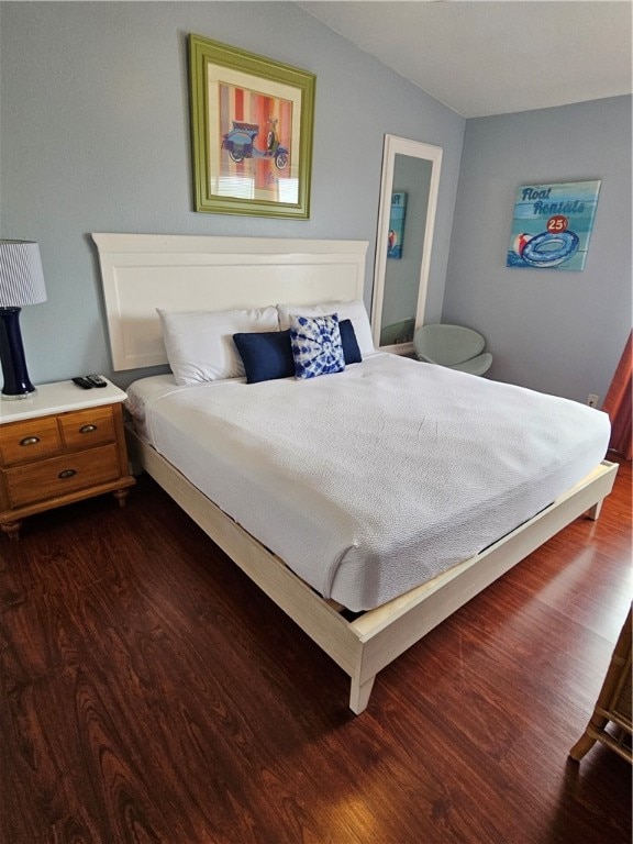 bedroom featuring dark hardwood / wood-style flooring and vaulted ceiling