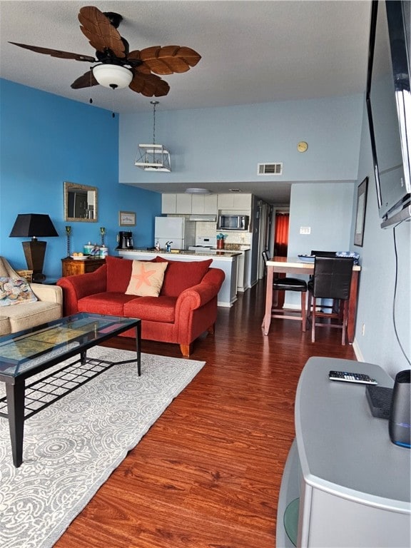 living room featuring dark wood-type flooring and ceiling fan