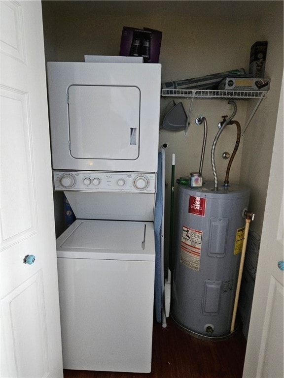 laundry area with electric water heater, stacked washer / dryer, and dark hardwood / wood-style flooring