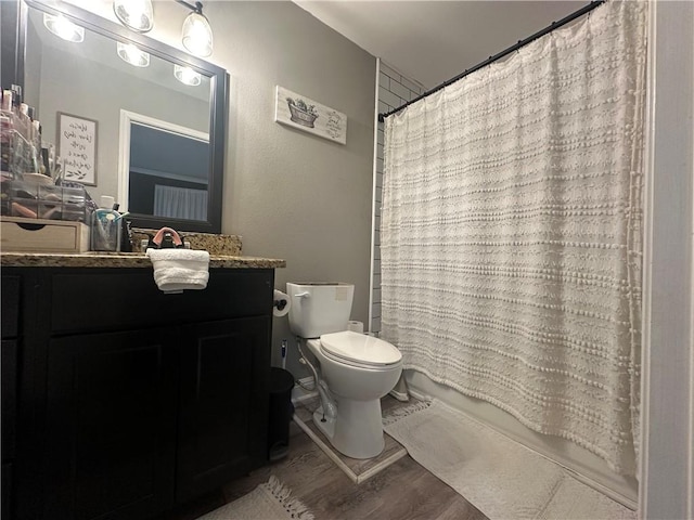 bathroom with hardwood / wood-style flooring, vanity, walk in shower, and toilet