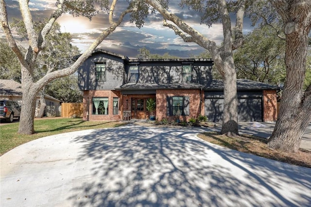 view of front of property with driveway, fence, a front lawn, and brick siding