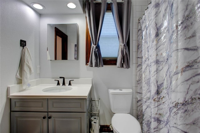 bathroom featuring vanity, toilet, and curtained shower