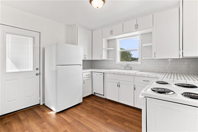 kitchen featuring tile counters, white cabinets, hardwood / wood-style floors, sink, and white appliances