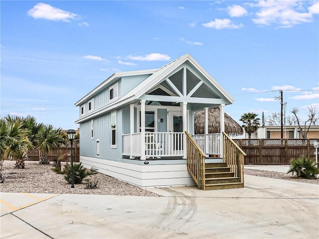 view of front of house featuring a porch and fence