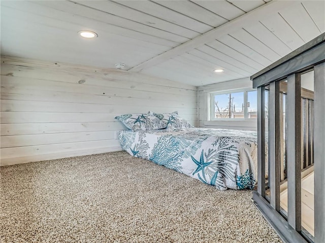 bedroom featuring carpet, wood walls, and lofted ceiling with beams