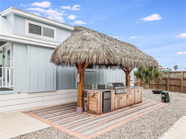 view of patio with a sink, fence, and area for grilling