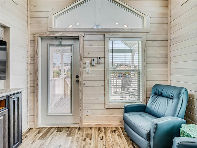 interior space featuring light wood-style floors and wooden walls